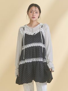 Model wearing the women's dress with a light lace hooded top layered under a black polka-dot tiered outer dress.