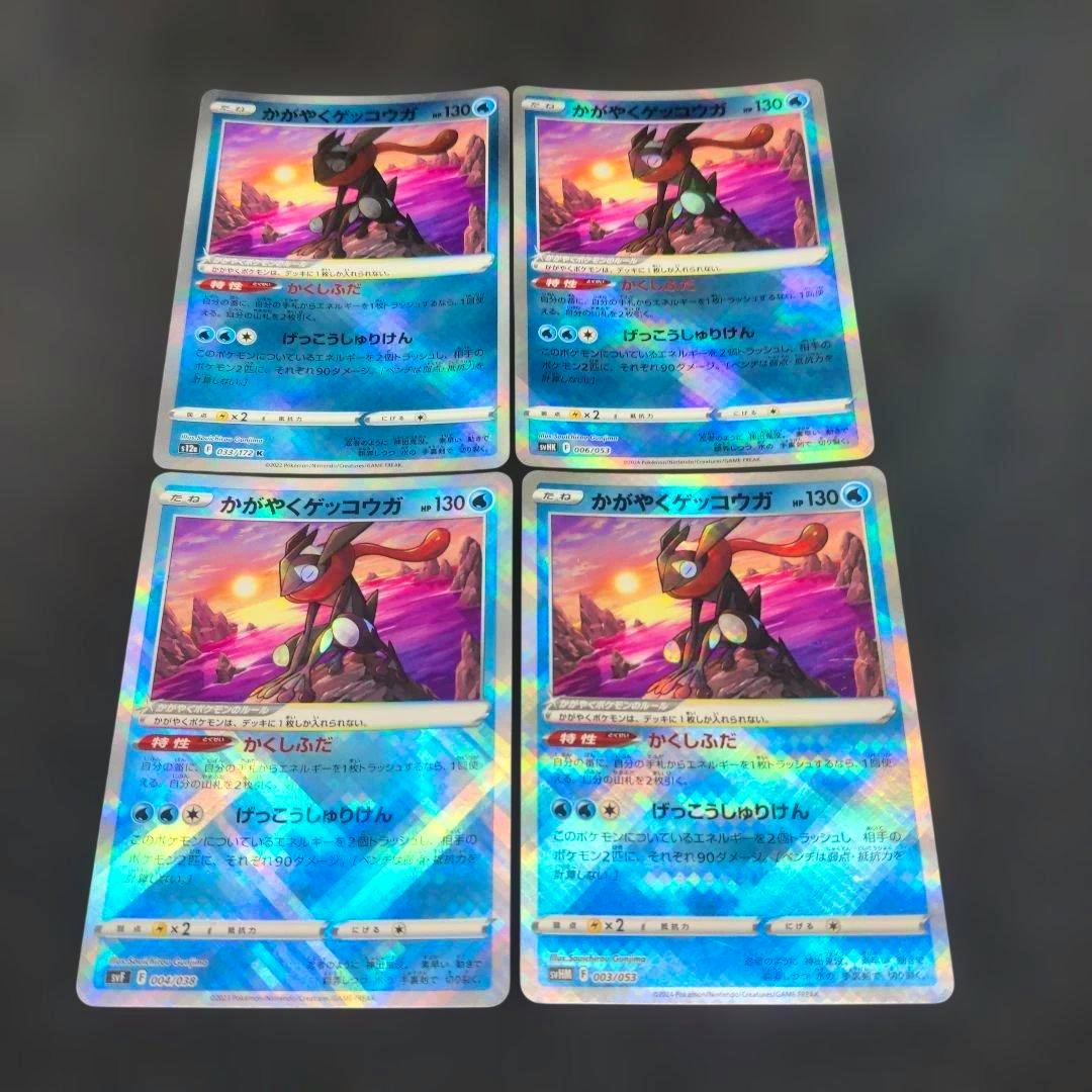 Four holographic Japanese かがやくゲッコウガ Pokémon trading cards arranged in two rows on a dark surface.