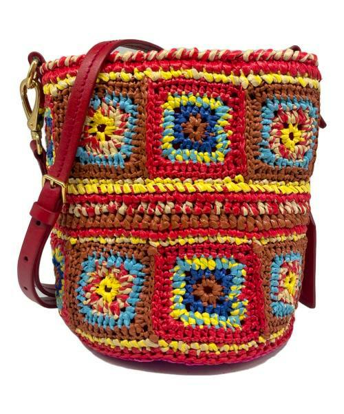 A colorful raffia crochet shoulder bag with square crochet motifs and a red shoulder strap.