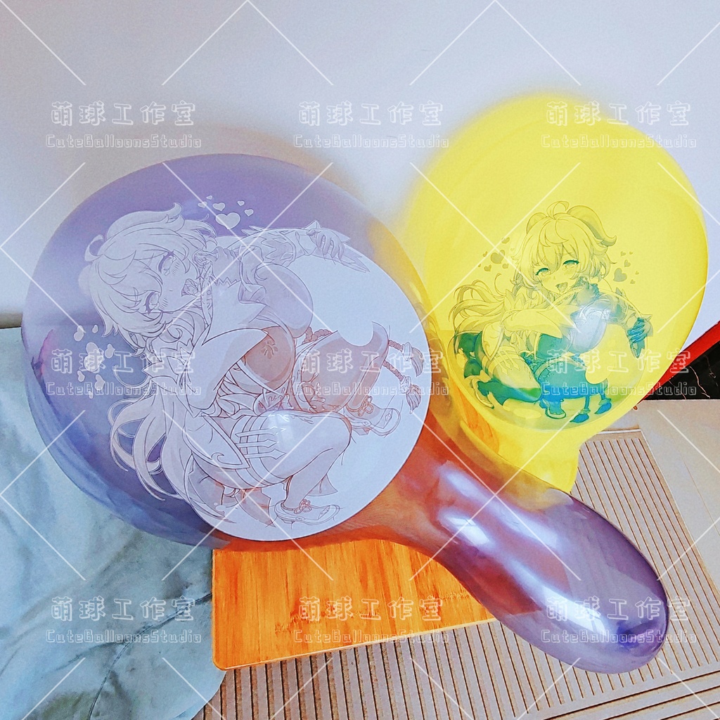 Two inflated balloons (one purple, one yellow) printed with anime-style character illustrations shown on a surface.