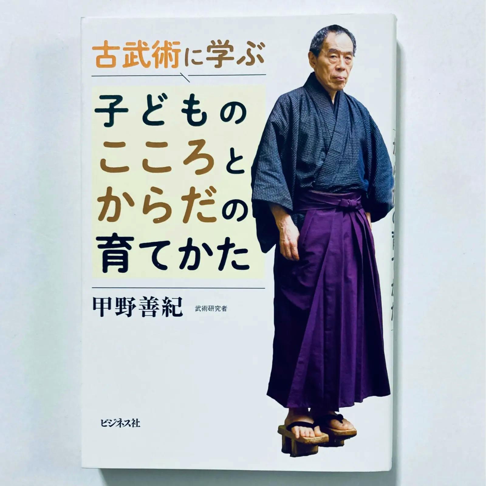 Front cover of the book showing the Japanese title and a man in traditional clothing standing on wooden sandals.