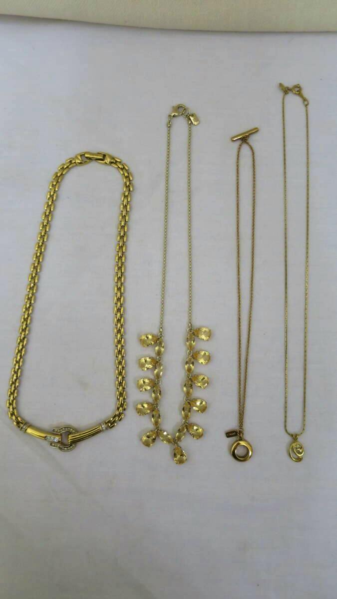 Four gold-tone necklaces laid flat on a white background, shown side by side.