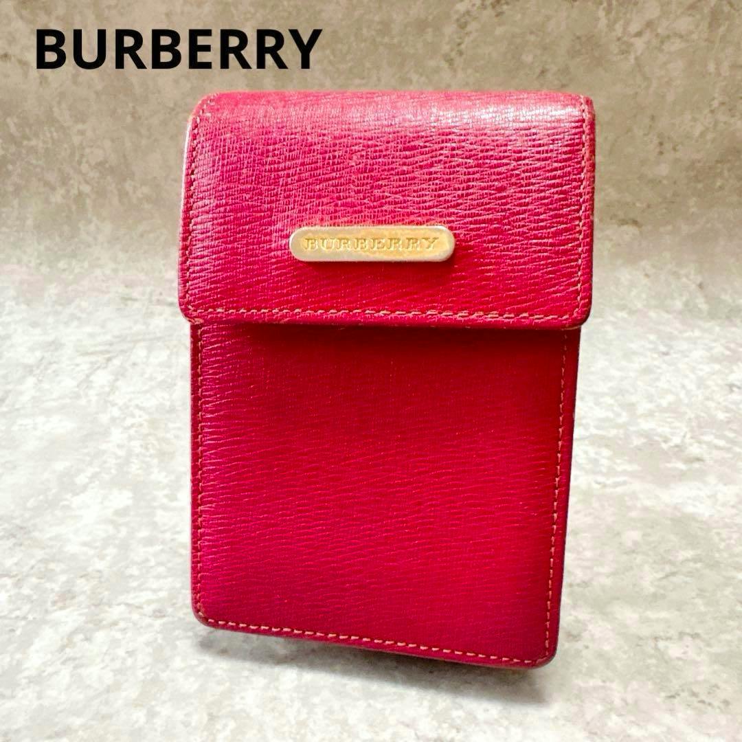 Front view of a red leather Burberry cigarette case with a flap and a small Burberry nameplate.