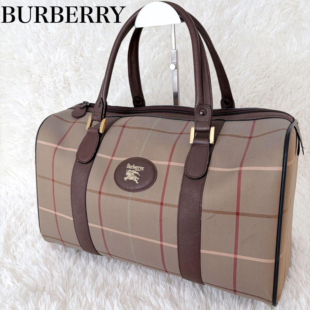 Burberry Boston bag in Nova Check pattern with dark brown leather handles and straps on a white background.