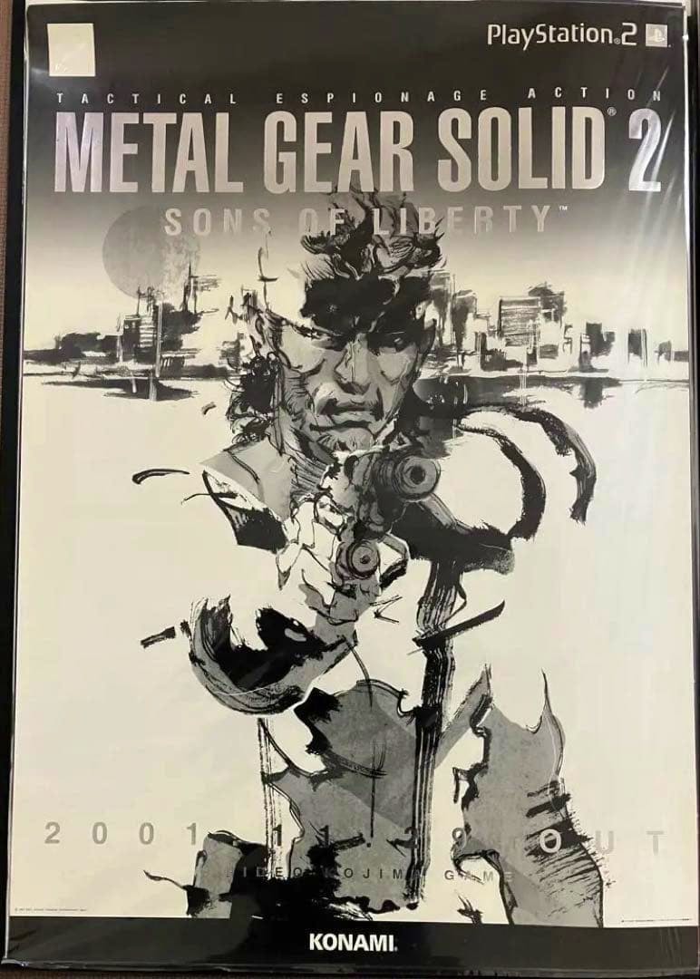 Photograph of a Metal Gear Solid 2 promotional poster showing a monochrome illustration of a man aiming a handgun, the game's title at top, and the KONAMI logo at bottom.