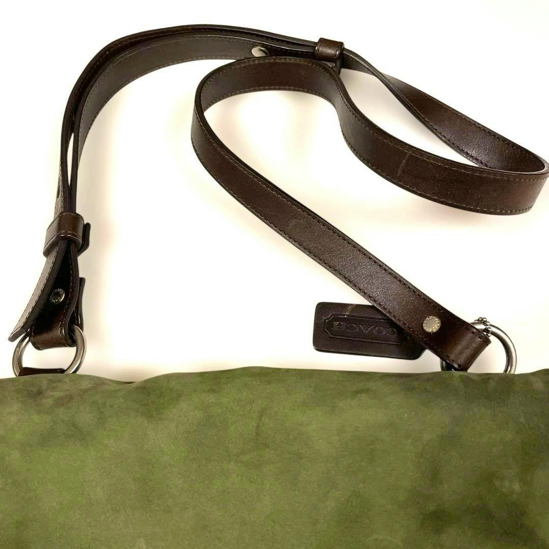 Moss green leather Coach shoulder bag showing brown leather strap and a Coach leather hang tag.