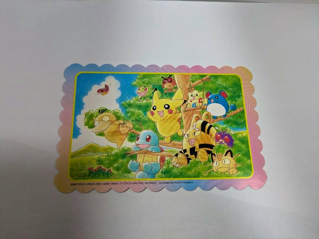 A scalloped-edge vintage Pokémon postcard showing Pikachu and other Pokémon in a colorful outdoor illustration.