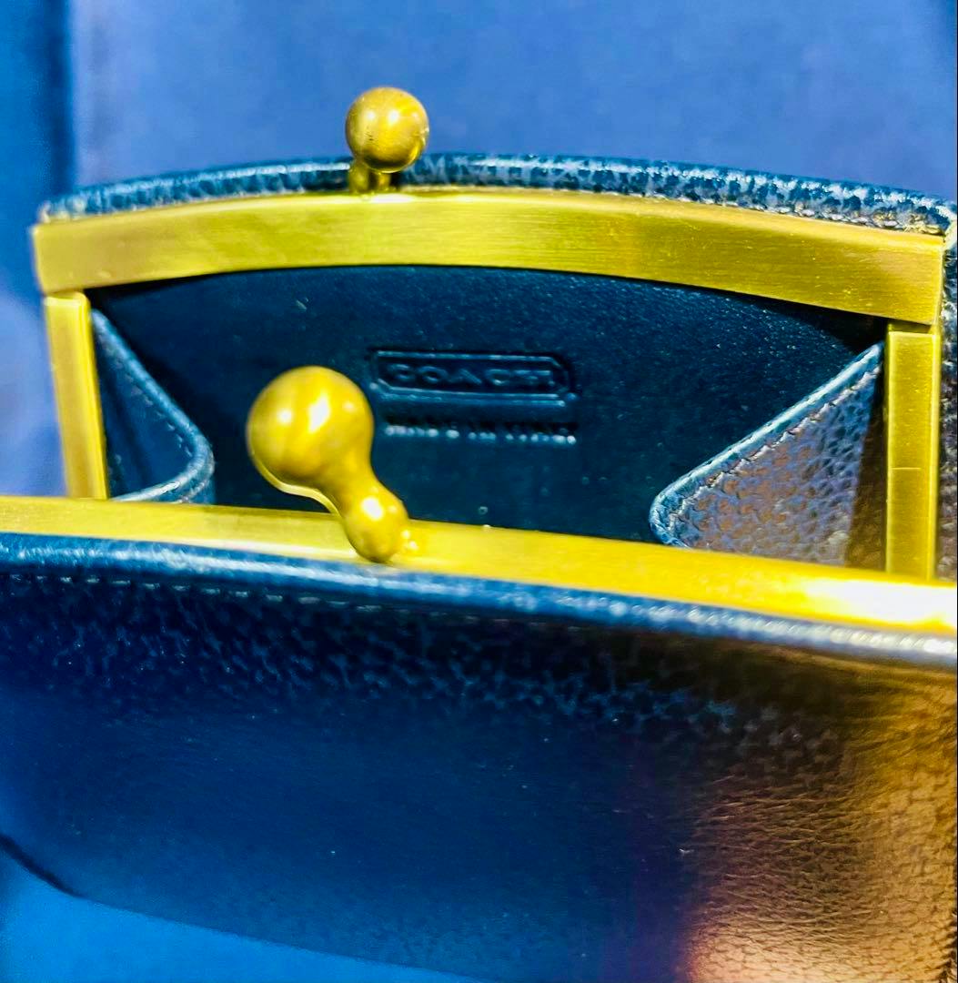 Cow leather coin case (がま口) with a gold-tone kiss-lock frame and the embossed COACH logo visible inside.