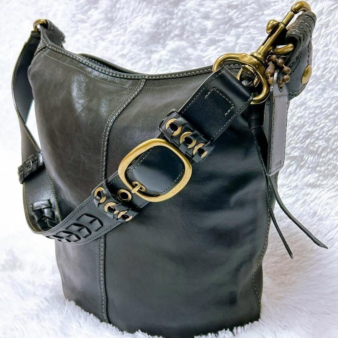 Black Old Coach leather shoulder bag with a wide strap and brass buckle hardware shown on a white background.