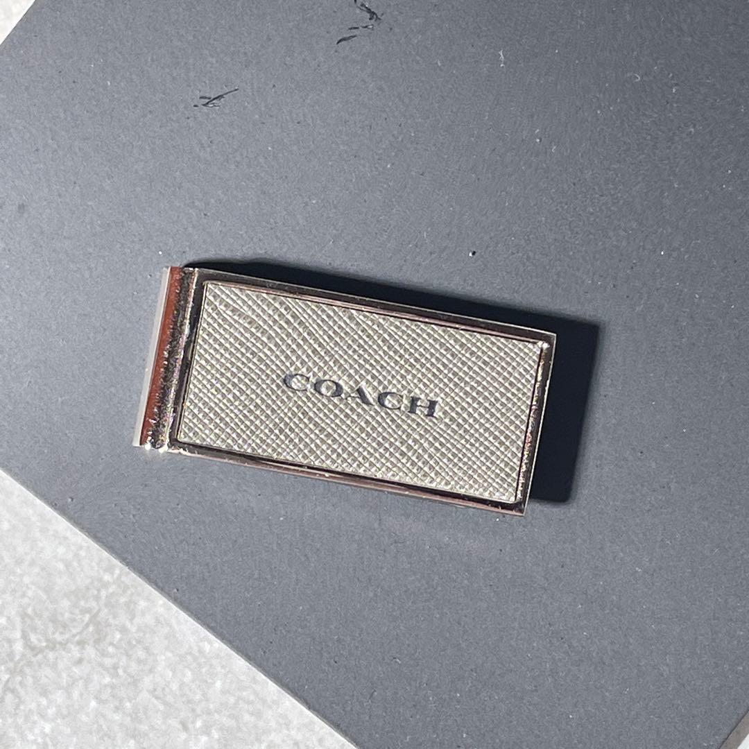 Front view of a stainless steel Coach money clip with a textured rectangular face and COACH logo.