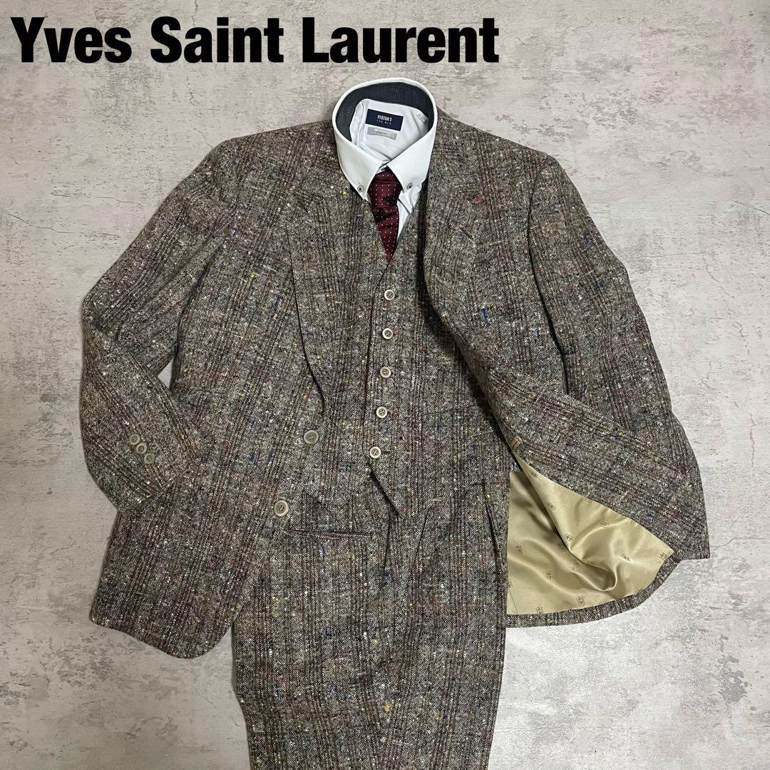 Flat-lay of an Yves Saint Laurent tweed three-piece wool set (jacket, vest, trousers) displayed on the floor.