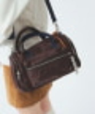 A brown Boston-style bag with top handles and a shoulder strap shown worn by a model.