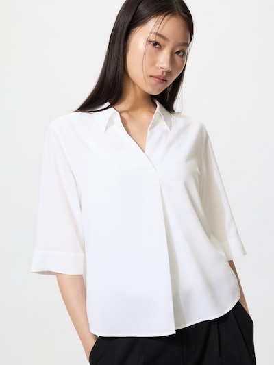 A model wearing a white rayon skippa blouse with three-quarter (7/10) sleeves.