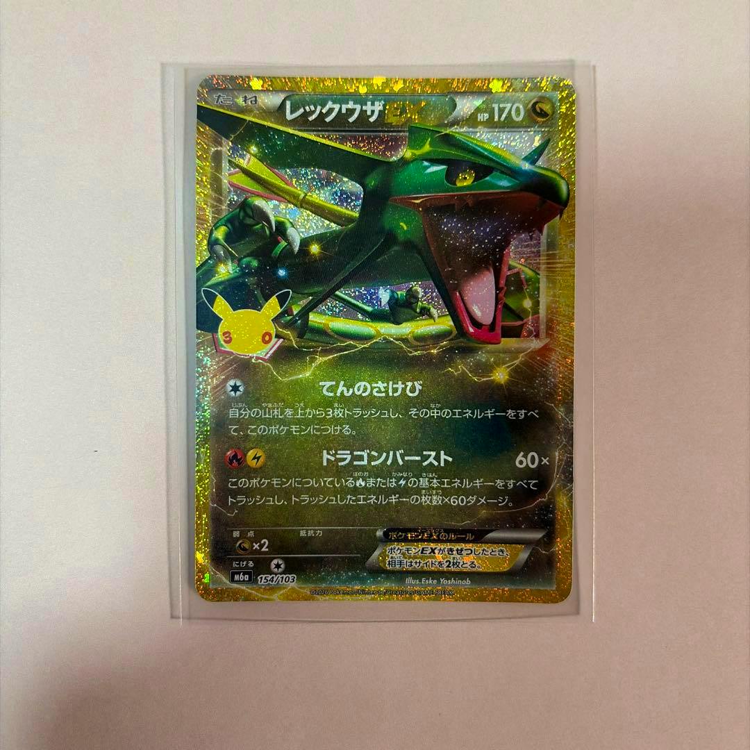 Holographic レックウザEX (Rayquaza EX) Pokémon trading card in a clear protective sleeve on a pink background.