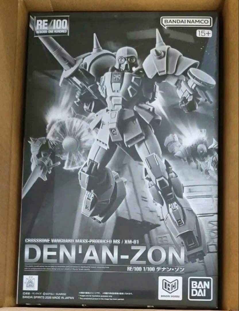 Boxed RE/100 1/100 Den'an-Zon model kit front cover photographed inside a cardboard box.