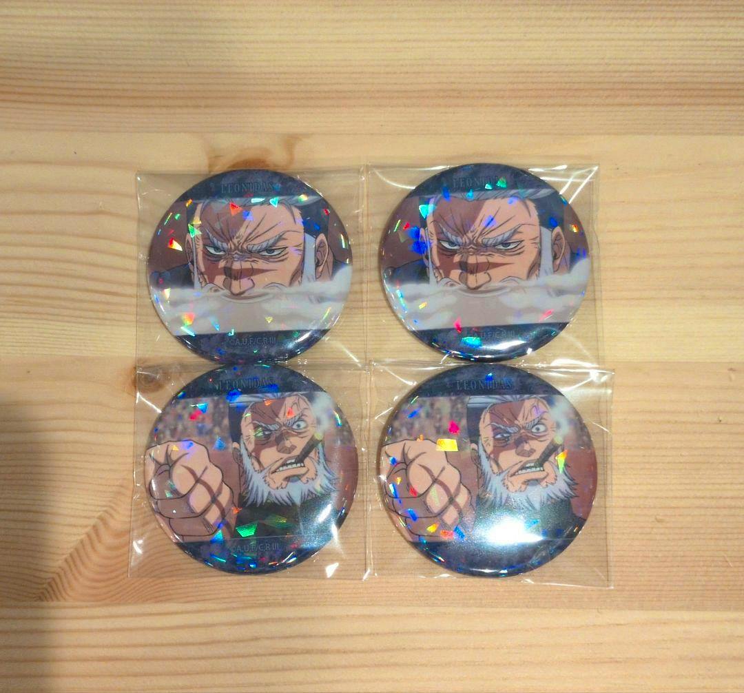 Four round holographic can badges featuring Leonidas from 終末のワルキューレ shown in sealed plastic on a wooden surface.