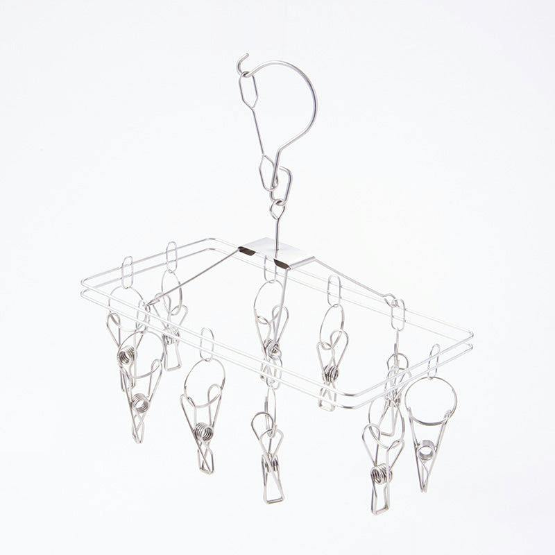Rectangular stainless steel pinch hanger with ten metal clips hanging from a hook.