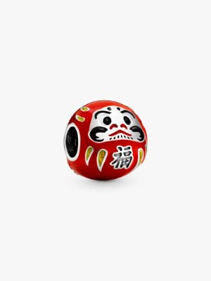 Red Daruma doll charm with a silver inner core and painted facial features on a white background.