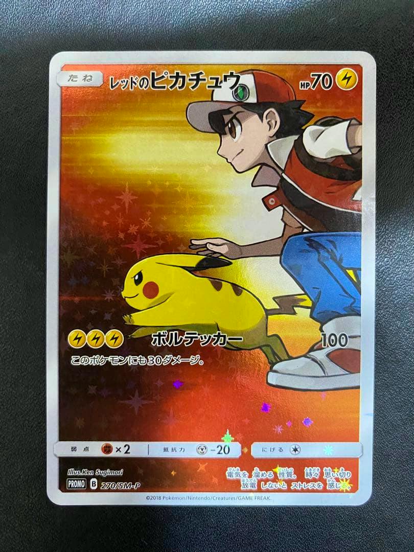 Front of the trading card showing Red and Pikachu with Japanese text and a holographic background.