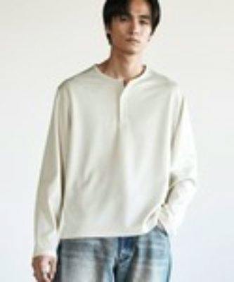 Front view of a man modeling a light-colored refined waffle henley neck long-sleeve tee.