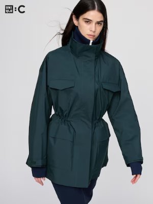A model wearing the men's short stand-collar coat showing front flap pockets and a drawstring waist.