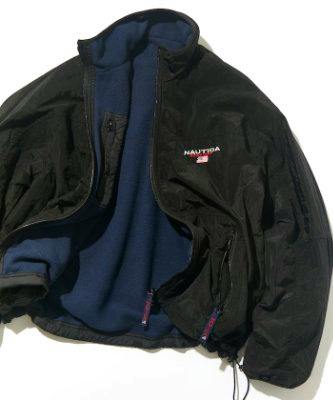 Black reversible nylon men's jacket with blue fleece lining and Nautica logo laid flat with the zipper open.