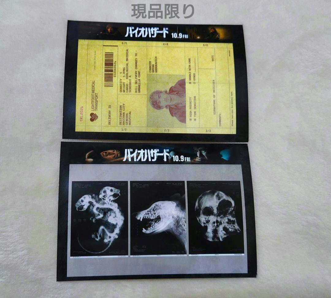 Two バイオハザード (Resident Evil) bromide photographs on a light background; the top print shows a yellow document design and the bottom shows three X-ray style images.