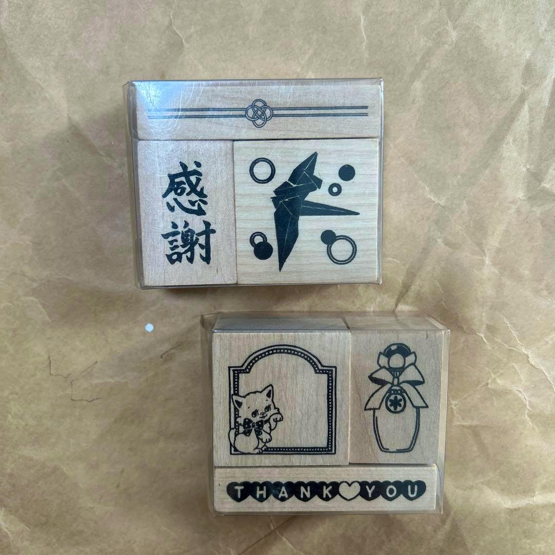 Photo of two wooden rubber stamps in plastic packaging showing a '感謝' kanji stamp and decorative stamp designs.