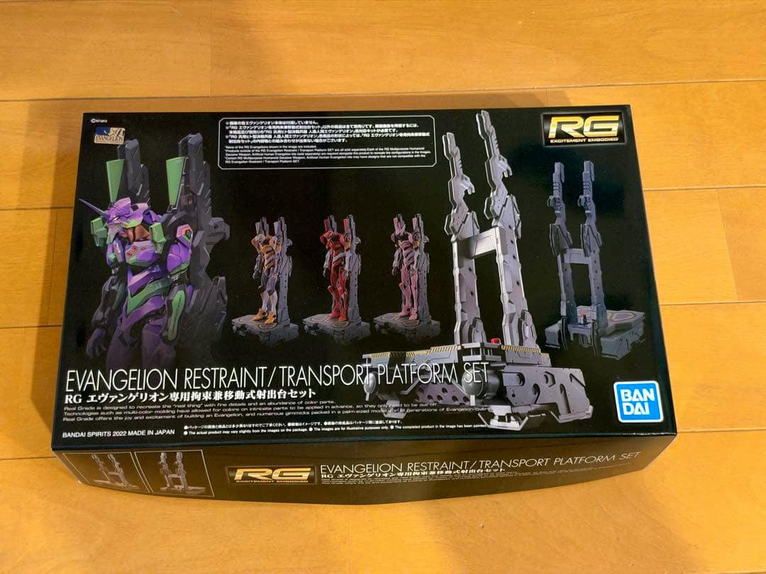 Top of the RG Evangelion Restraint/Transport Platform Set model kit box showing product artwork and the Bandai logo.