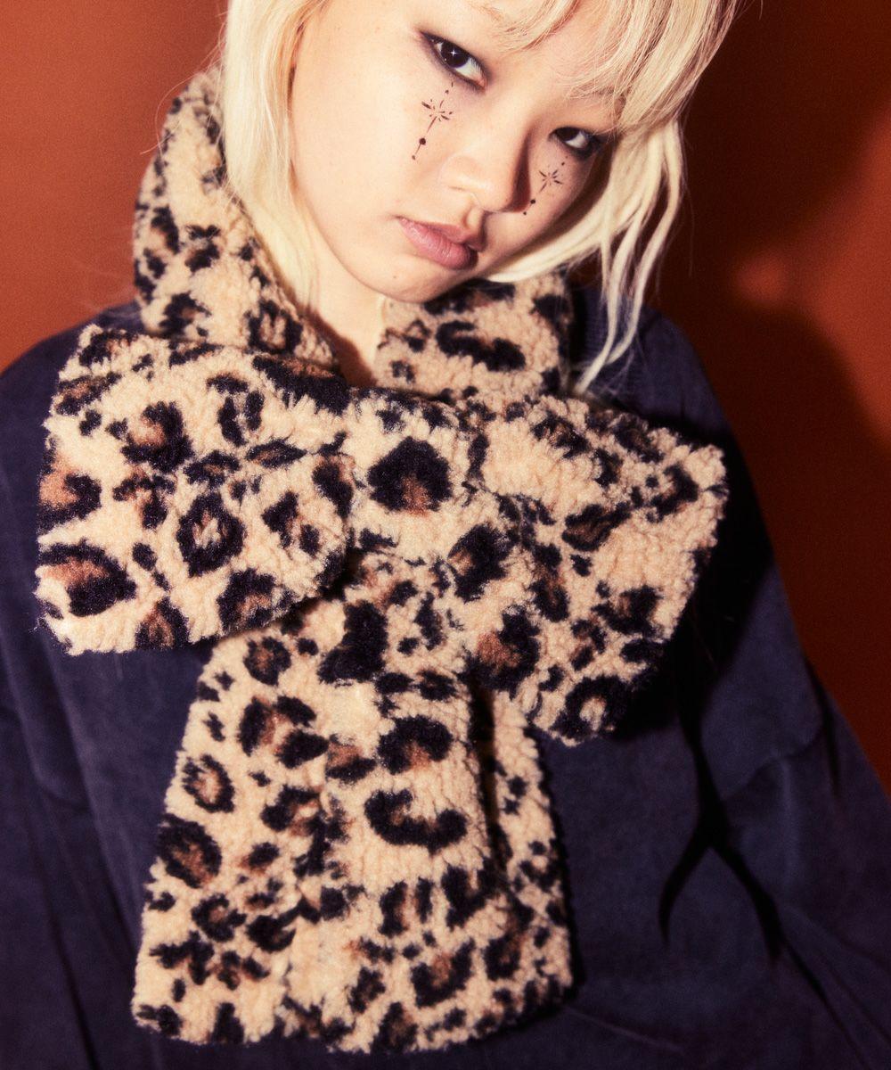 Model wearing a leopard-print ribbon muffler scarf tied at the front.