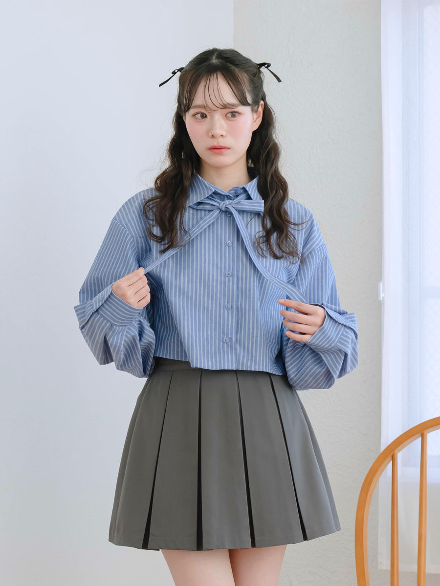 Front view of a model wearing the ribbon stripe shirt: a blue striped blouse with a front ribbon tie.