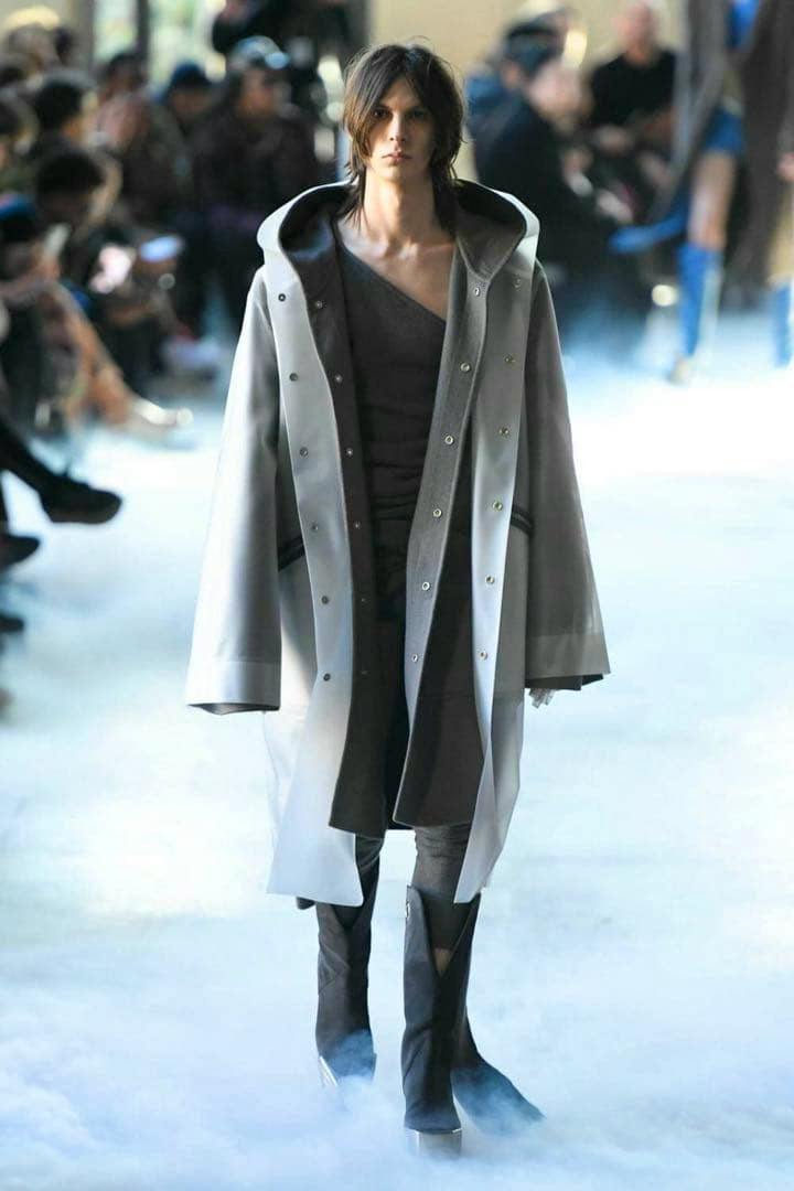 Model wearing the Rick Owens transparent hooded long coat on a runway.