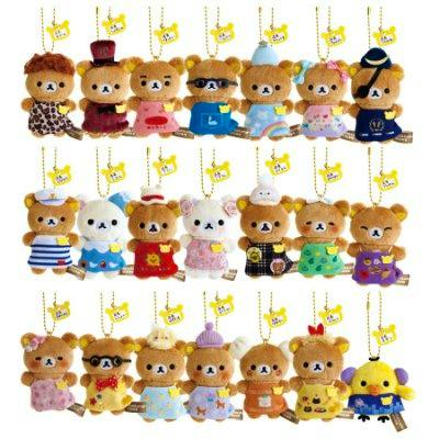 Photo of multiple small hanging Rilakkuma plush keychains arranged in rows, showing different outfits and colors.