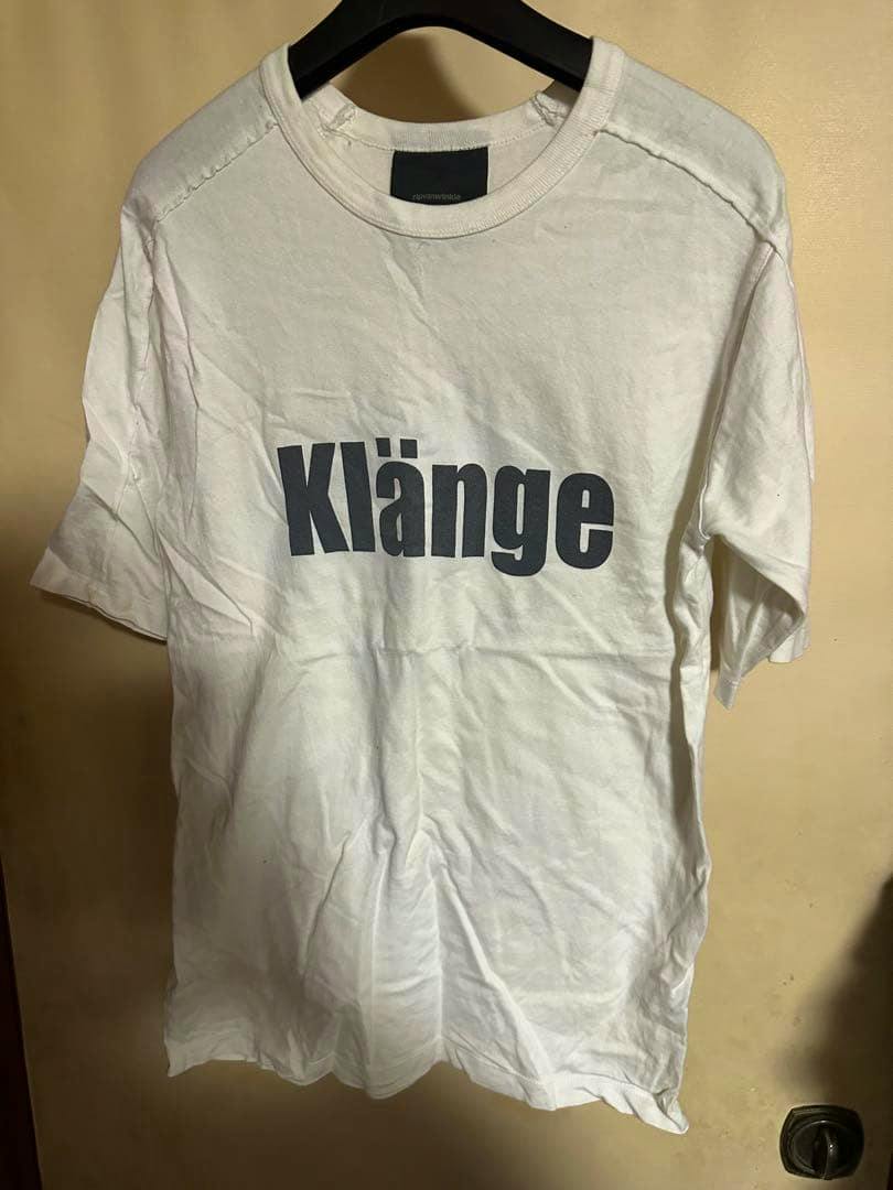 White RIPVANWINKLE cotton T-shirt on a hanger showing the 'Klänge' print on the front.