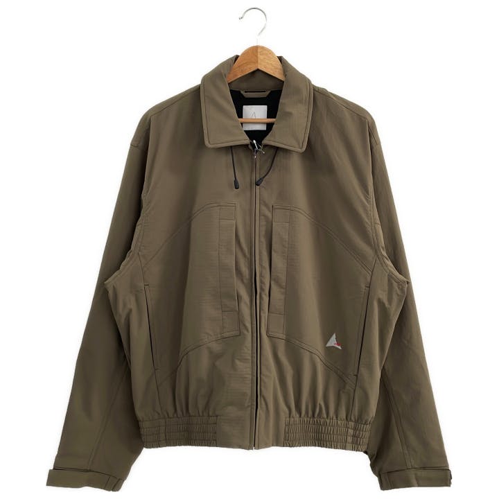 Front view of the brown ROA Pilot men's nylon jacket hanging on a hanger against a white background.