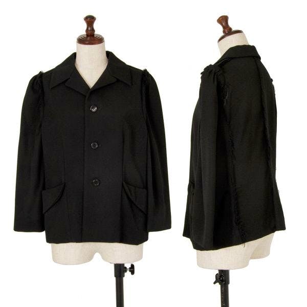Front and side views of a black jacket by COMME des GARÇONS displayed on a dress form.