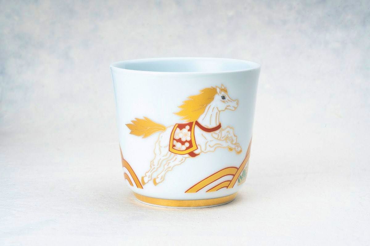 Porcelain rock cup with a leaping white horse design and stylized wave motifs on the surface.