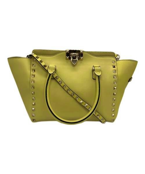 Yellow leather Rockstud 2-way shoulder handbag shown from the front with studs, top clasp, two handles and a shoulder strap.