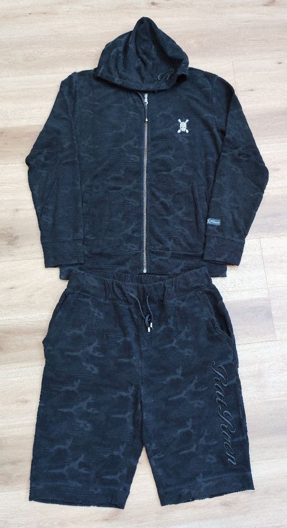 Men's polyester room wear set with a zip-up hoodie and matching shorts laid flat on a wooden floor.