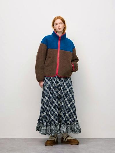 A model wearing the ruffle (frill) skirt with a plaid pattern shown full-length against a plain background.
