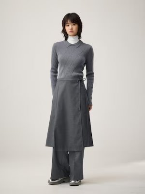 A model wearing the gray wrap pants, showing the wrap panel layered over matching trousers.