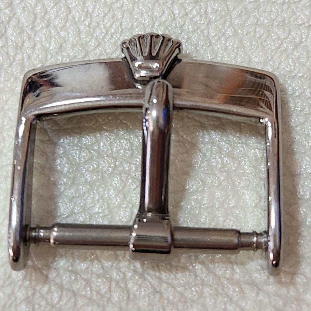 Close-up of a stainless steel 16mm watch band buckle with a Rolex crown logo on a light textured background.
