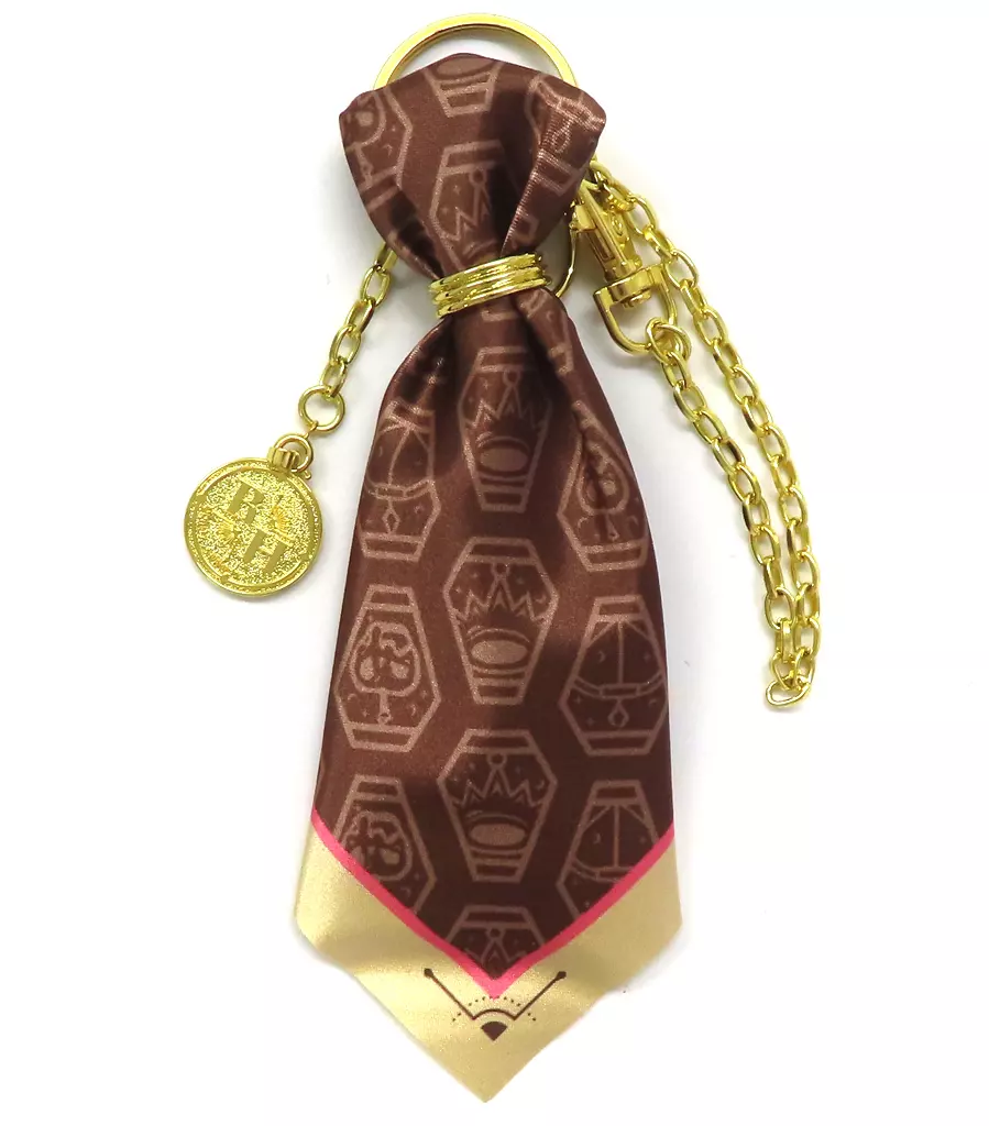 A gold-tone bag charm featuring a brown patterned polyester scarf pendant and a round coin motif on a short chain.