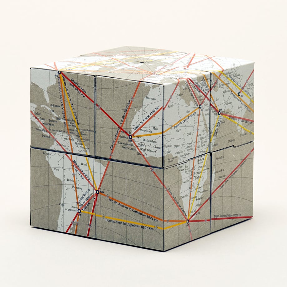 A folded cube of origami paper composed of eight small map-printed cubes.