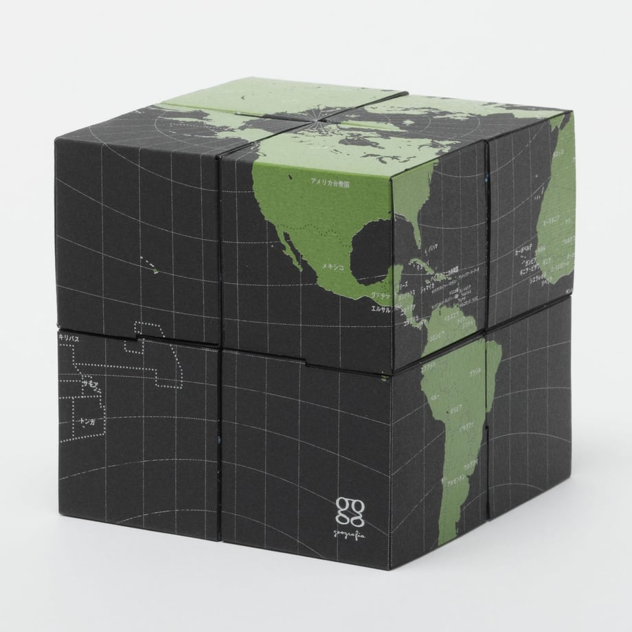 Assembled twistable globe of eight small cubes showing a green-and-black world map printed on origami paper.