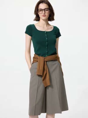A model wearing a green round-neck, button-front cardigan.