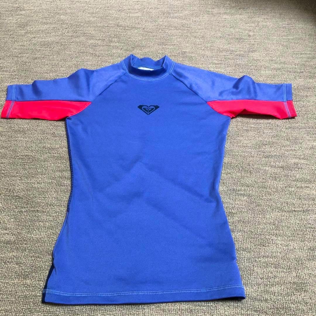 Front of a blue and pink ROXY kids XS rash guard laid flat showing the front and a small chest logo.