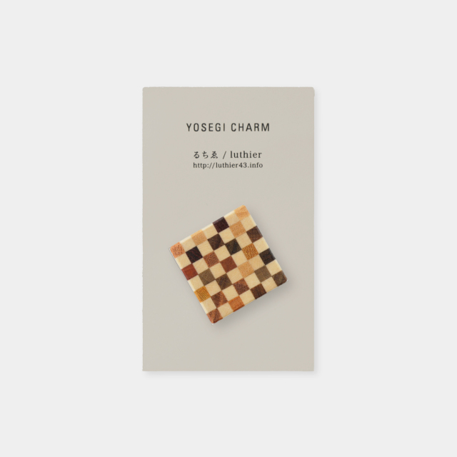Square yosegi wooden charm displayed on a card backing labeled "YOSEGI CHARM".