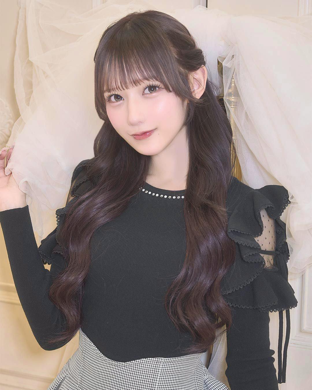 Close-up of a model wearing the black frill-shoulder bijou top, showing ruffled shoulder layers and a beaded neckline.