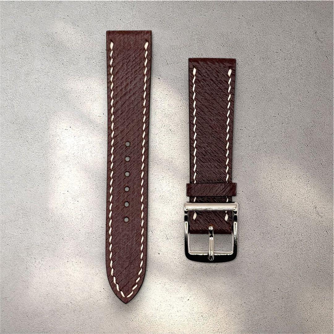 Brown 20mm leather watch strap with white stitching and a silver buckle laid flat on a gray background.